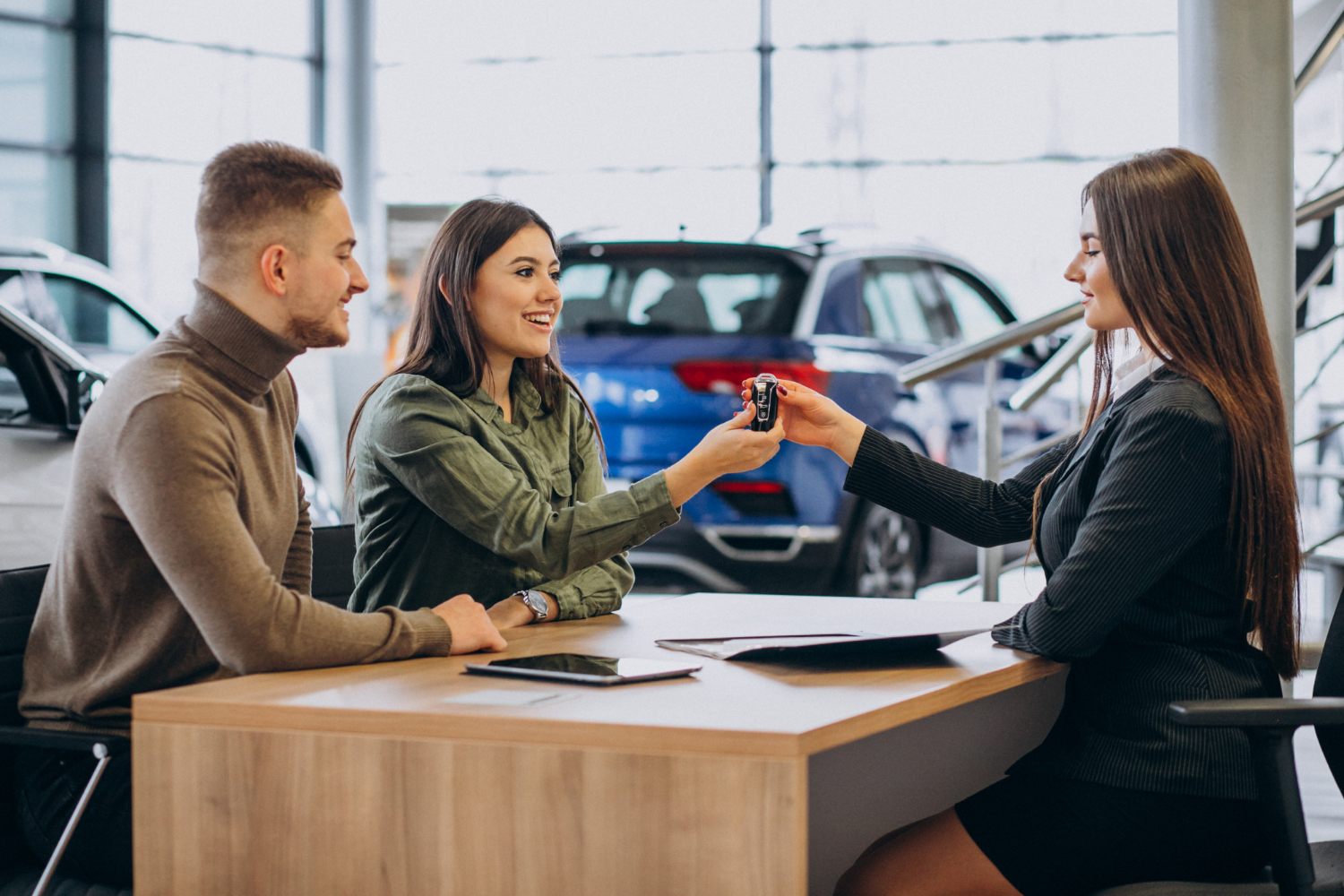 young-couple-talking-sales-person-car-showroom